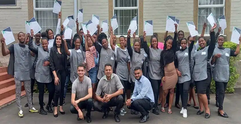 A group of PnS students who have just graduated from the PnS Academy holding up their certificates.